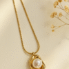 Gold pendant necklace with a white a pearl set in an irregular sculpted frame on a snake chain